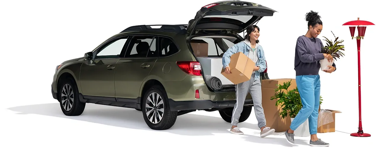 A pair of roommates unpack their SUV. They may save by combining the purchase or their auto and renters insurance.